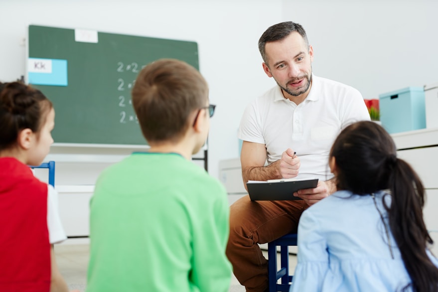 Teacher reading with two children in a classroom